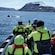 Five passengers on a boat photographing a breaching whale